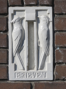 908486 Afbeelding van een staande dichtgezette en wit geschilderde aardewerken brievenbus naast de voordeur van het ...